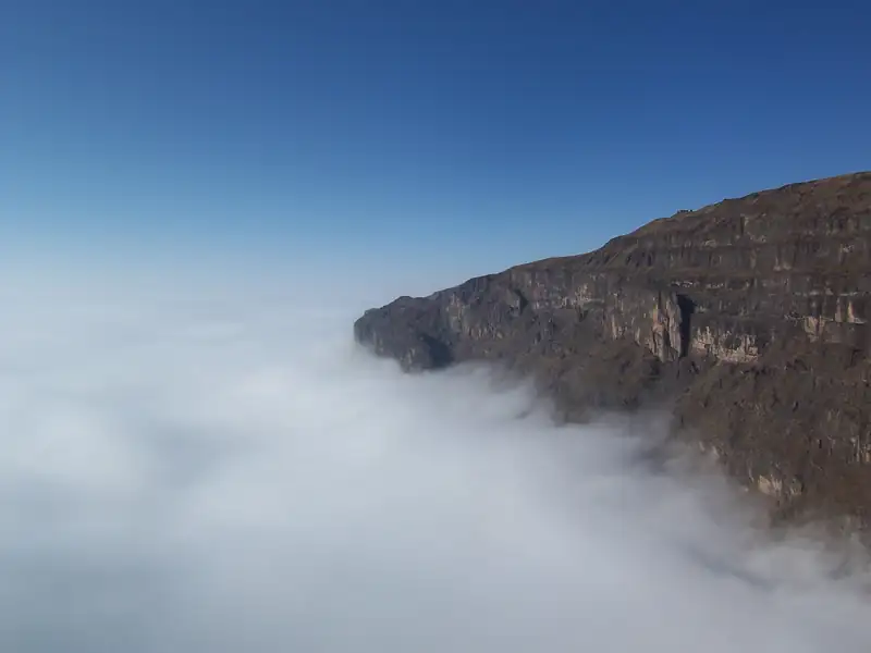 A sea of clouds pressing against the cliffs at the edge of the Dashanbao plateau