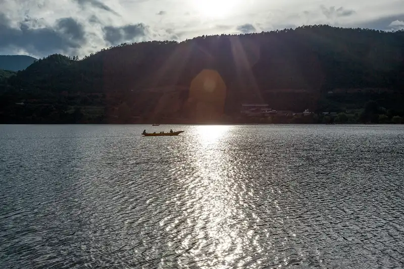 A boat crossing Lugu Lake in the evening light
