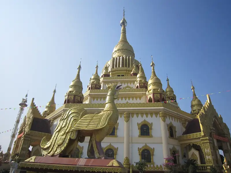 A bird statue in front of the Menghuan Golden Pagoda in Mangshi
