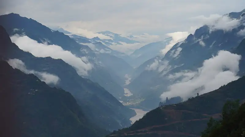 The Nujiang River running through a deep canyon between steep green slopes
