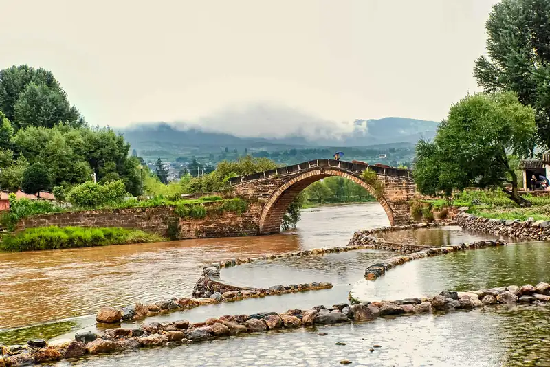 Fields and the old bridge outside Shaxi